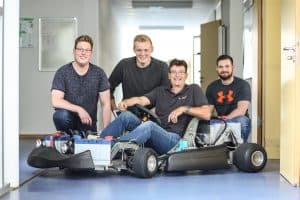 Studierende und Mitarbeiter der Westfälischen Hochschule mit einem im Studium entwickelten E-Go-Kart am Campus Bocholt.