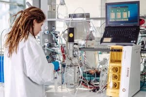 Eine Frau steht an einem Versuchsaufbau im Labor für Biotechnologie.