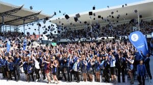 Graduierte werfen beim Graduiertenfest ihre Hüte in die Luft